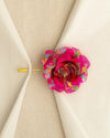 Decorative pink flower pin on a beige fabric background