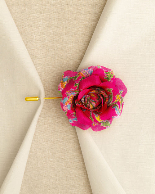 Decorative pink flower pin on a beige fabric background